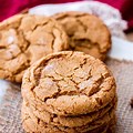 A plate showing a front stack of molasses sugar cookies with a few others in the background.